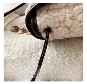 Close-up of fuzzy shearling texture with leather trim and gold vintage button detail