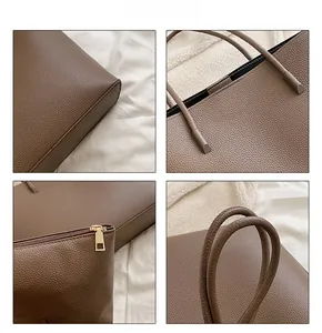 Detailed close-up of brown litchi grain leather texture and gold zipper on tote bag