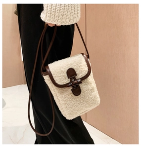 Detail view of plush crossbody phone bag with horn buckle and brown leather strap