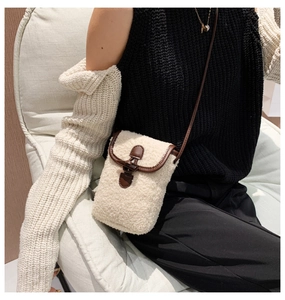 Close-up of faux shearling crossbody bag with vintage horn buckle and leather trim
