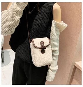 Detail view of plush faux fur crossbody bag with leather trim and horn button closure