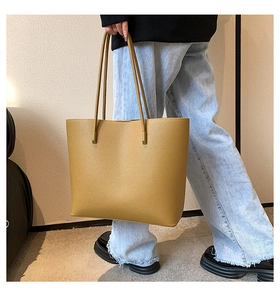 Detailed close-up of large ginger yellow tote bag with textured lychee grain finish