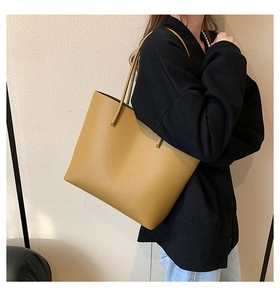Detail of ginger yellow tote bag featuring premium lychee texture and slim shoulder straps