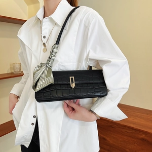 Sac baguette noir à motif crocodile avec foulard en soie et boucle dorée chic