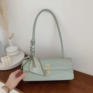 Sac baguette vert menthe à motif croco avec boucle dorée et détail de foulard rayé