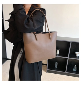 Detailed side view of dark brown pebbled leather tote bag on model for daily commuting