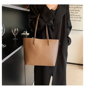 Detailed view of deep brown pebbled leather tote bag with long handles for daily work