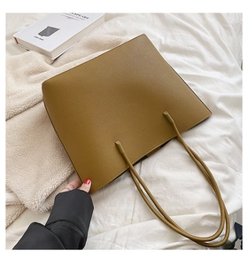 Close-up of mustard brown tote bag with premium lychee grain texture and long handles