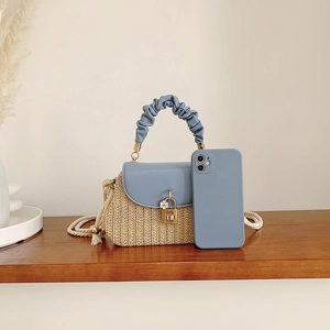 Mini straw crossbody bag with light blue leather flap and floral gold clasp accent