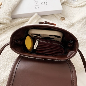 Capacity of the plush crossbody bag showing phone and wallet inside the main compartment