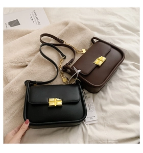 Detail of classic black and brown matte leather mini crossbody bags with gold buckles