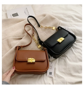 Detailed view of semi-moon flap crossbody bags with gold locks in black and brown leather