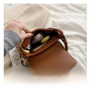 Detailed interior of a brown leather mini bag showing storage capacity for essentials