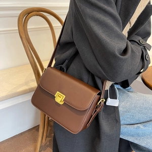 Retro brown faux leather crossbody bag with a gold metal clasp and adjustable strap
