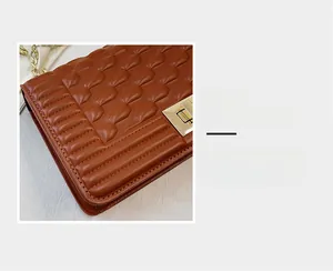 Détails de la texture en cuir matelassé marron et du fermoir en métal doré pour sac femme