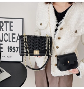 Détail du sac à rabat noir texturé avec chaîne dorée et pochette bandoulière minimaliste