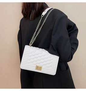 Détail du sac blanc en similicuir avec texture embossée et chaîne dorée