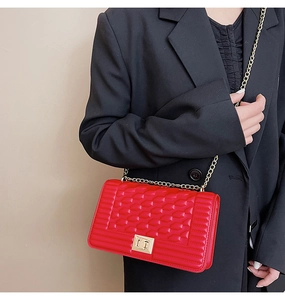 Détail du sac bandoulière rouge matelassé avec chaîne dorée et fermoir métallique