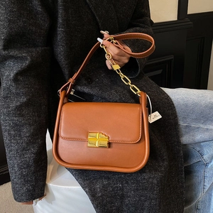 Brown leather crossbody bag with gold chocolate-shaped buckle and chain strap