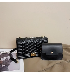 Détail de l'ensemble sac bandoulière matelassé noir et pochette en cuir lisse