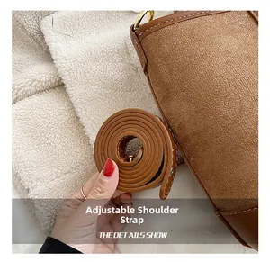 Close-up of adjustable leather strap and textured suede stitching on brown bucket bag