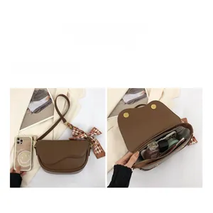 Detail view of large capacity dark brown saddle bag with bow ribbon and internal compartments