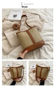 Close-up of khaki and brown paneled bucket bag with litchi texture and gold hardware