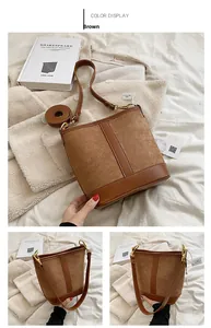 Detailed view of a brown bucket bag featuring mixed leather textures and gold hardware