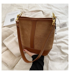 Detail of caramel bucket bag featuring a stylish mix of suede and smooth leather textures