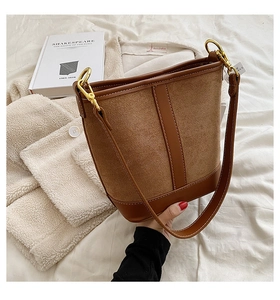 Detail of vintage brown bucket bag showing contrast texture and gold hardware