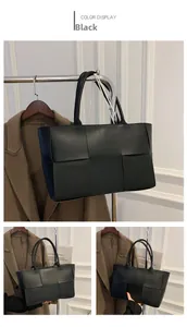 Detail view of black woven faux leather tote bag with wide strips and dual handles