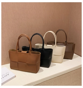 Collection of woven leather tote bags in caramel, black, cream, and brown colors