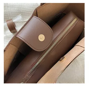 Detail of brown litchi pattern tote with gold hardware and magnetic closure