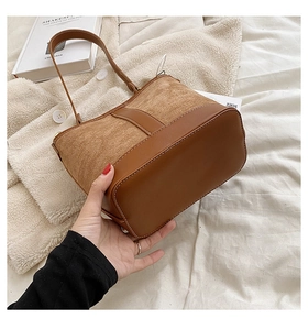 Detail of brown patchwork shoulder bag featuring white contrast stitching and soft PU leather