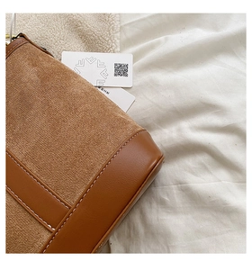 Detail view of brown patchwork bucket bag with suede texture and contrast stitching
