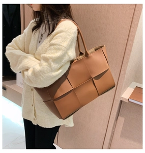 Close-up of caramel woven leather texture on a large tote bag for professional women