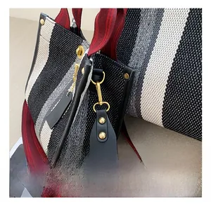 Detail showing high-quality golden metal hook and striped canvas texture on tote bag