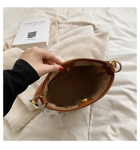 Top view of spacious brown bucket bag interior with pockets and gold ring details