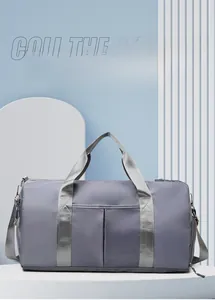 Detail of grey waterproof nylon travel bag showing functional pockets and handles