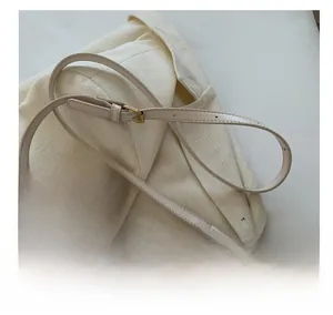 Macro shot of adjustable off-white faux leather shoulder strap with gold metal buckle