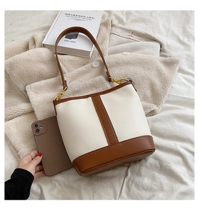 Interior storage capacity view of bicolor bucket bag showing space for a smartphone