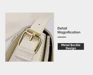 Detail der verstellbaren goldenen Metallschnalle am weißen Leder-Schultergurt der Tasche