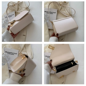 Detail view of cream crossbody bag featuring golden hardware and inner zip pocket