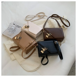 Detail view of four chic rectangular crossbody bags with gold locks on a white fabric base