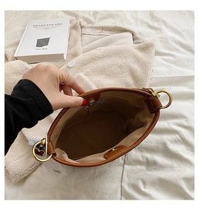 Interior view of brown leather bucket bag showing lining and gold hardware details