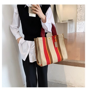 Detail of striped canvas tote bag showing thick texture and premium leather edging