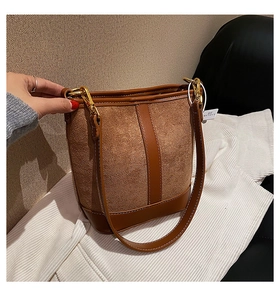 Detail showing vintage brown patchwork bucket bag with smooth leather and gold hardware