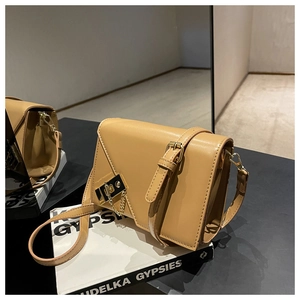 Detail of camel leather crossbody bag with golden clasp and accordion side gusset