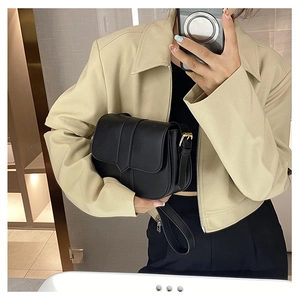 Spiegelselfie einer Frau mit schwarzer minimalistischer Umhängetasche mit goldener Hardware