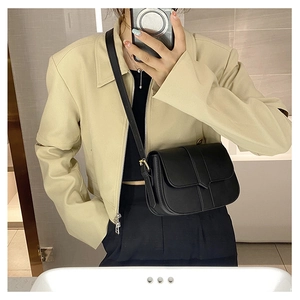 Detailansicht einer schwarzen matten Satteltasche aus Leder mit goldenen Schnallen